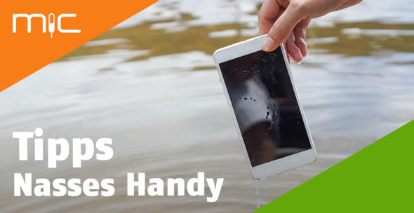 Eine Frau hält ein nasses Handy über einem Gewässer.